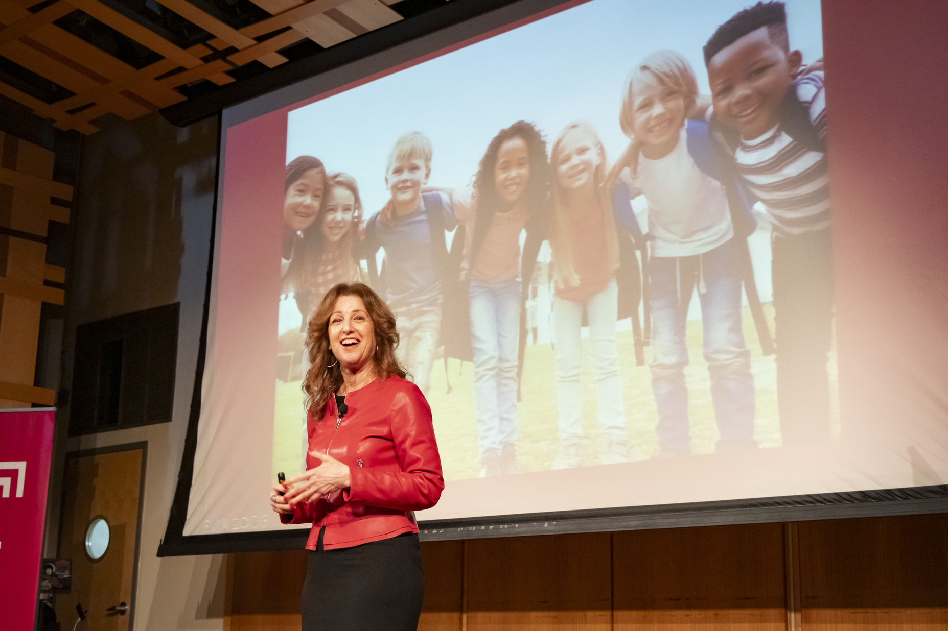 Sherri Hope Culver in front of a screen displaying children