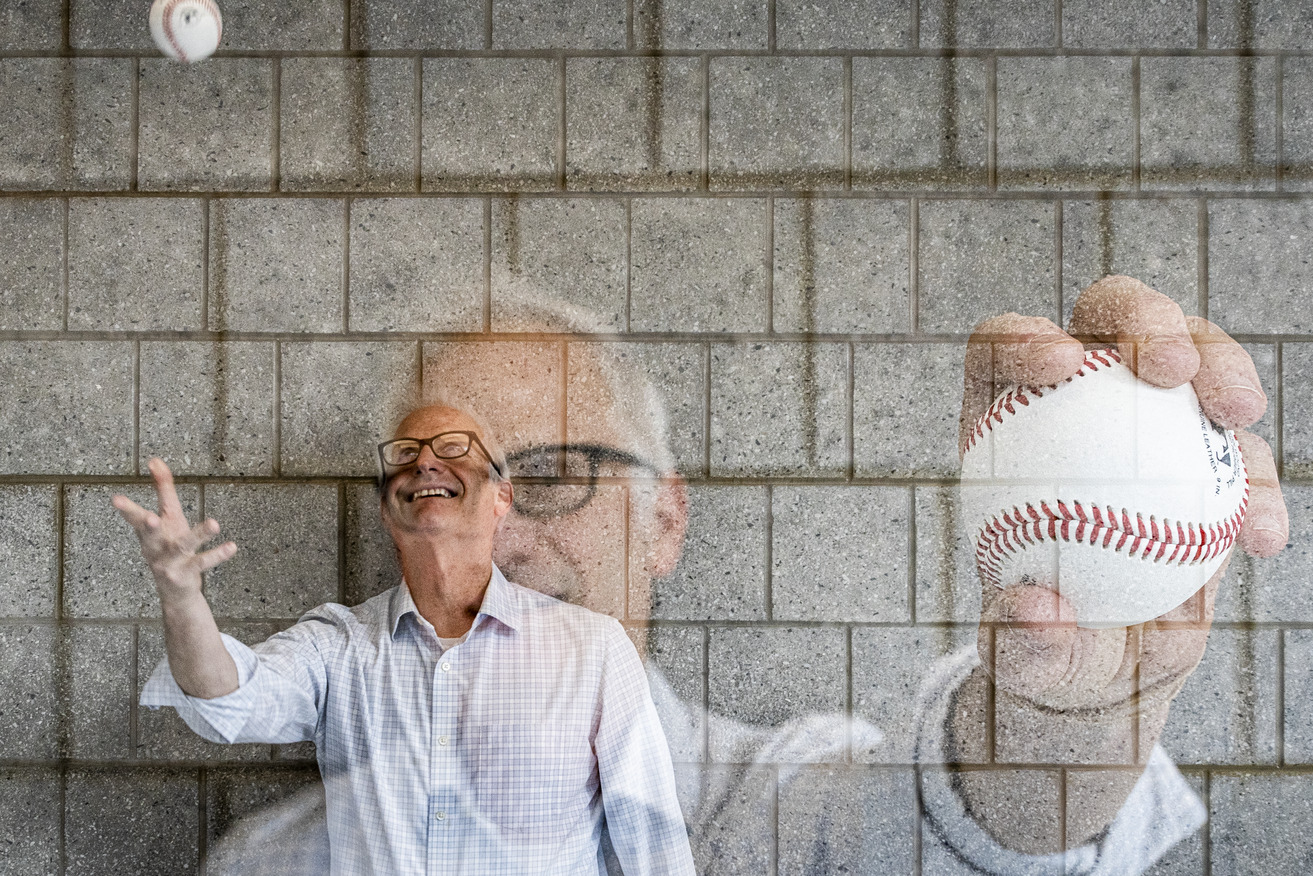 Image of a college professor tossing an MLB baseball.