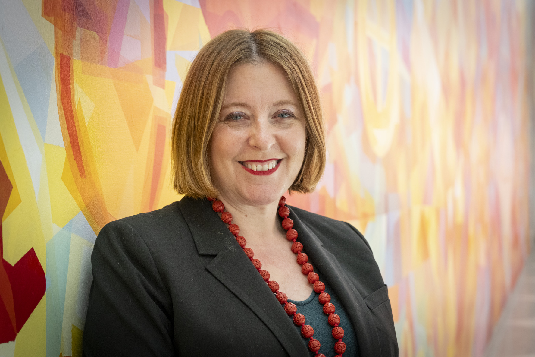 Erika Tapp Duran standing against a colorful background