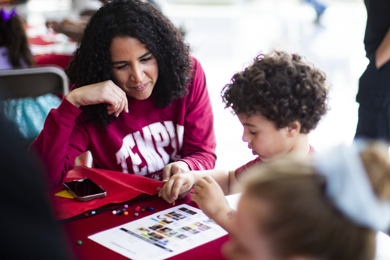 Image of a child with a parent wearing cherry white shirts at Temple.