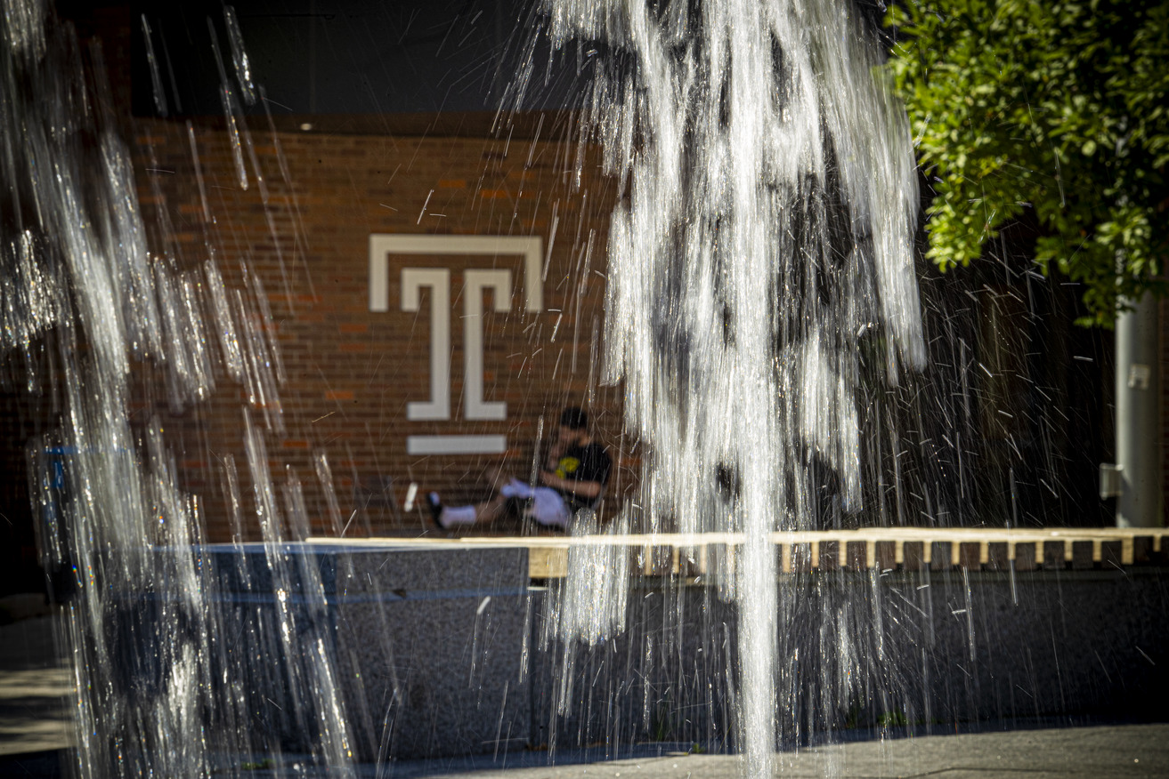 A student is pictured behind a fountain.