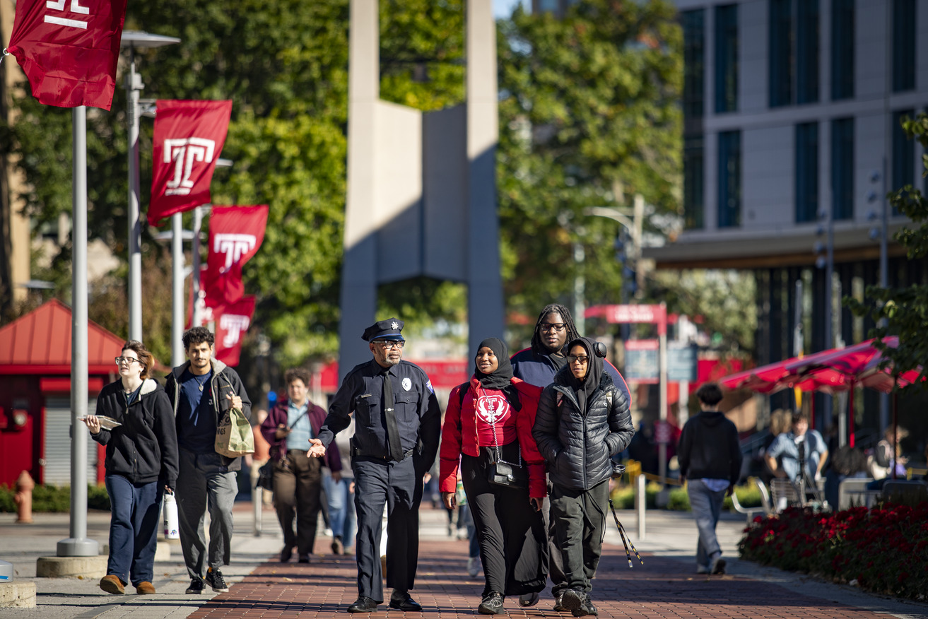 Image of three former Carver High School students with a Temple police officer.