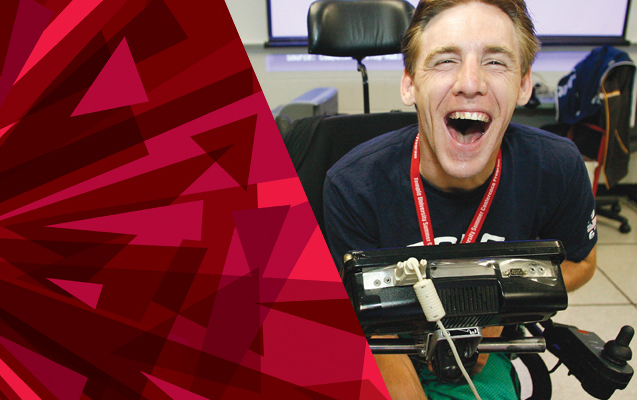 Male student, laughing, using a speech generating device.