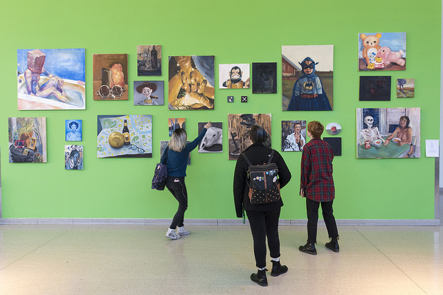 Students looking at a green hallway gallery