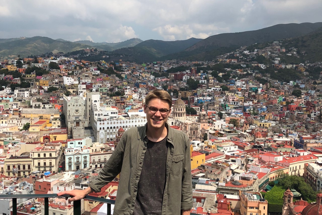 Alex Voisine standing in front of a cityscape.
