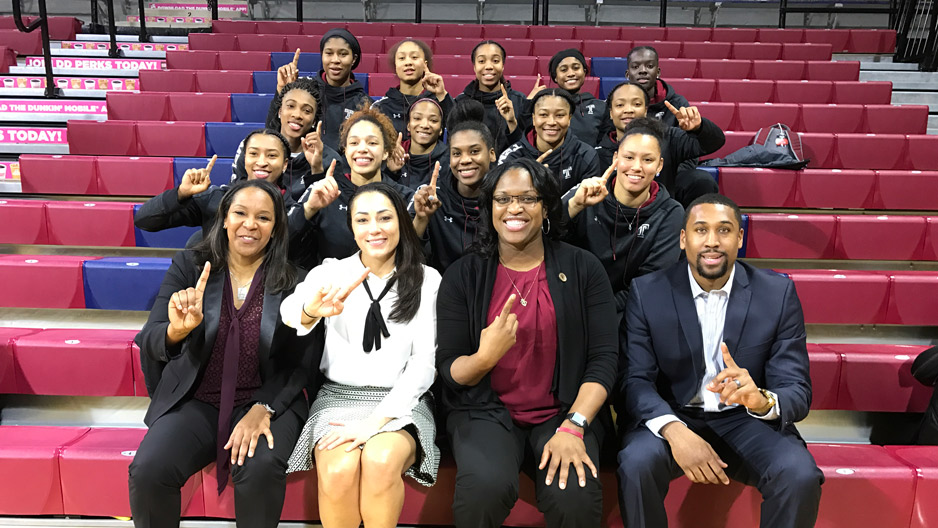 the Temple women s basketball team holding up their fingers to signify No. 1.