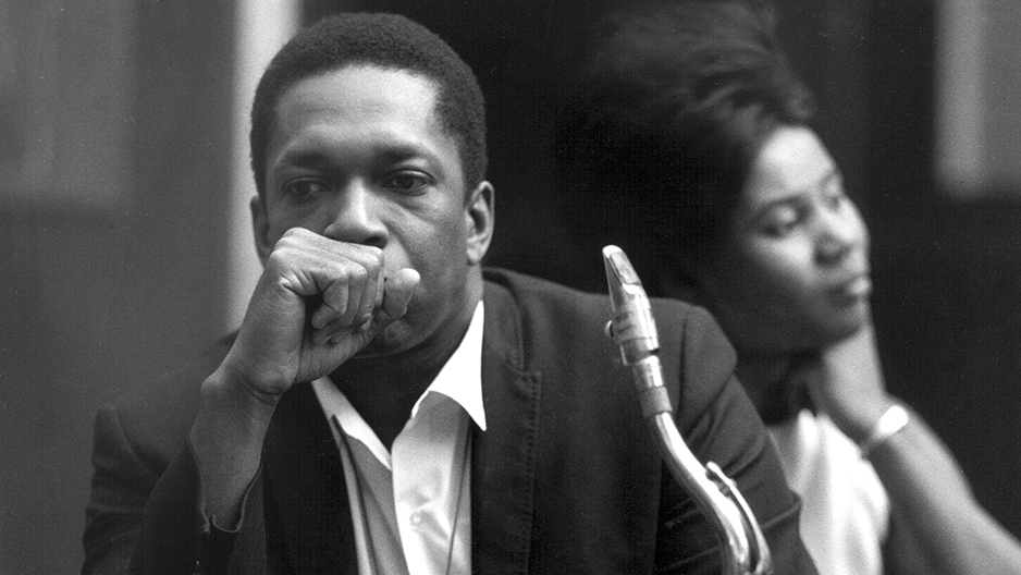 Coltrane sitting with his saxophone.