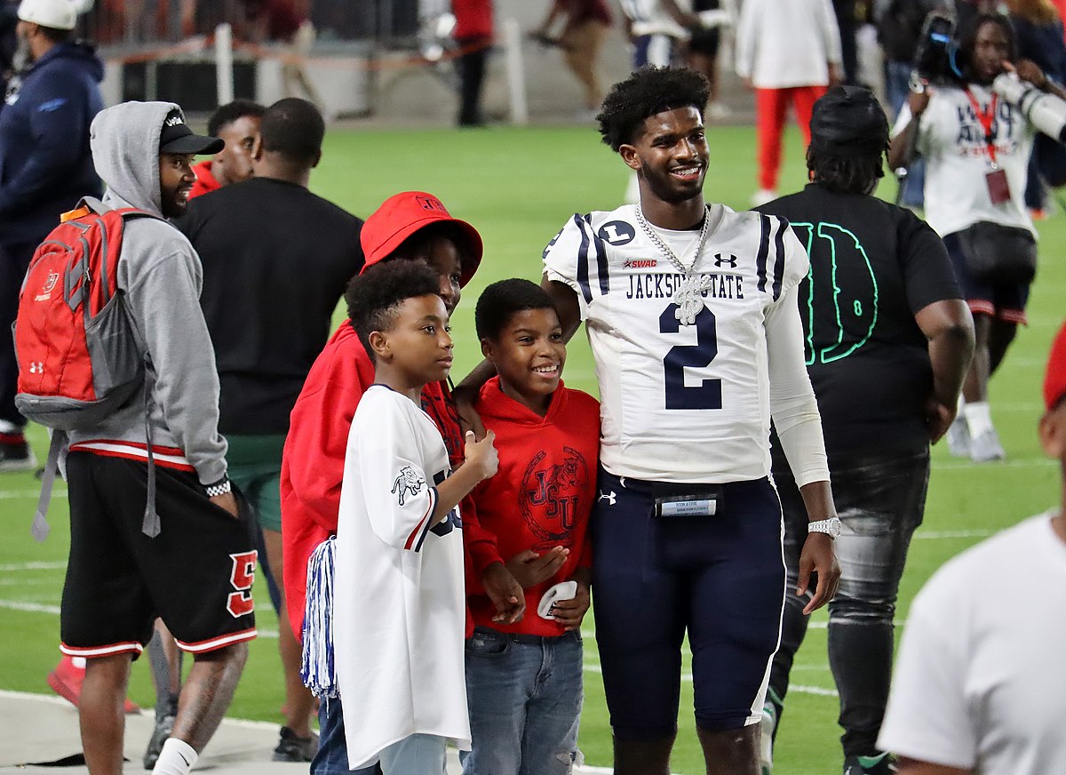 Shedeur Sanders pictured with two young men.