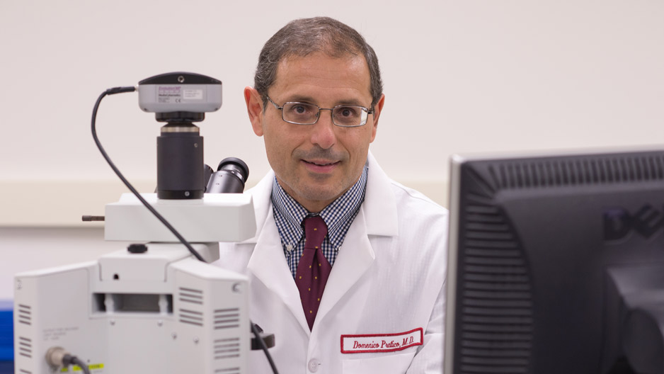 Domenico Pratic , professor of pharmacology, wearing a lab coat.