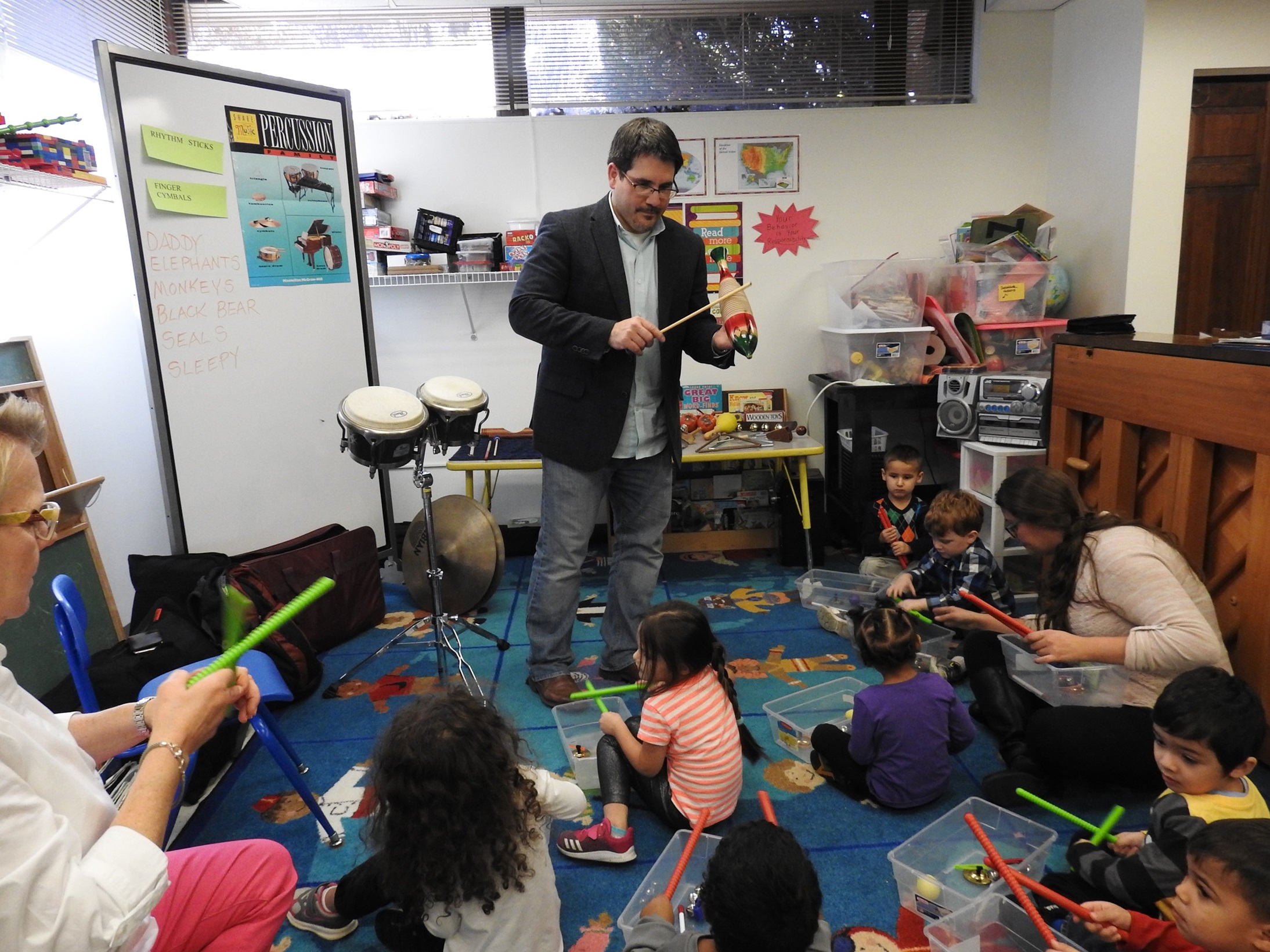 Steven Weiser, BYR 02, 04, teaches a percussion lesson to a group of students.