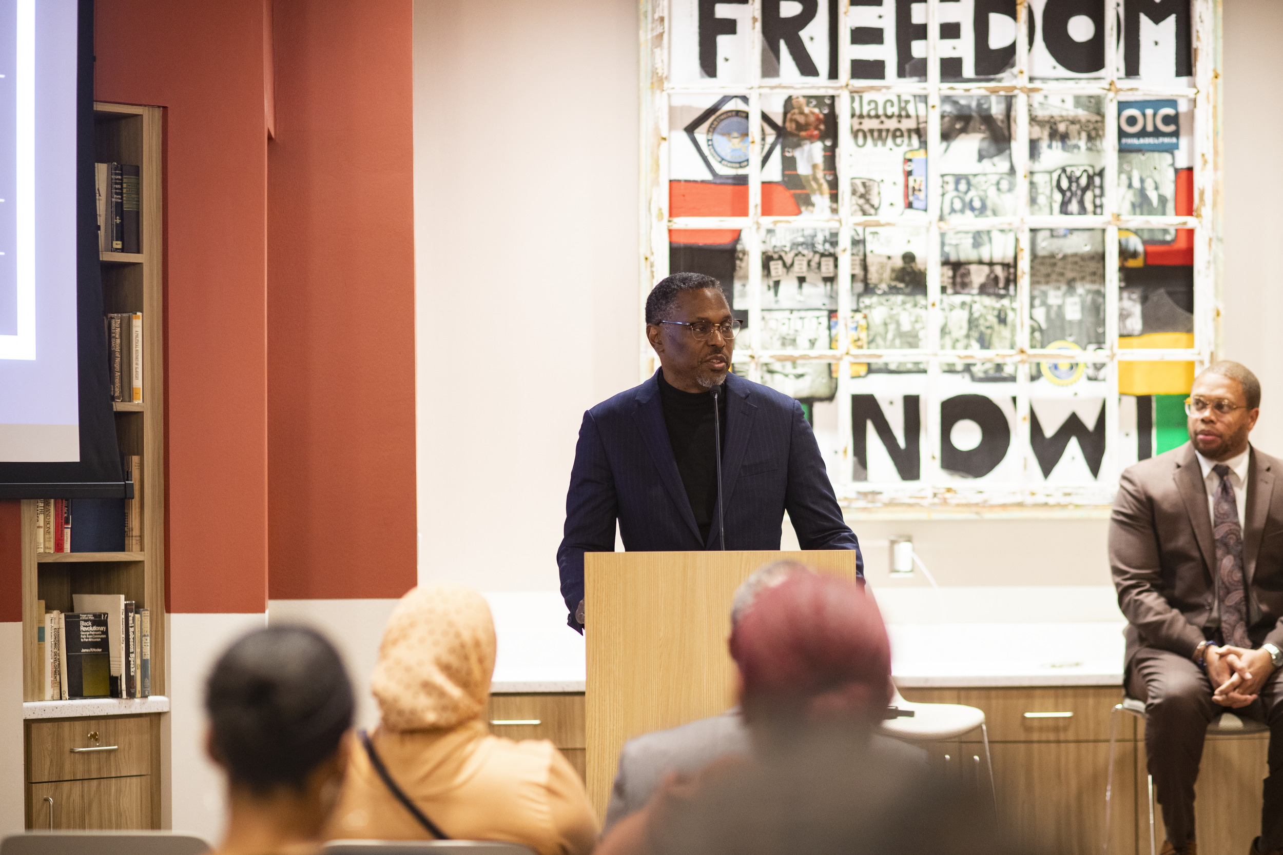 Rev. Gregory Holston speaking at a podium