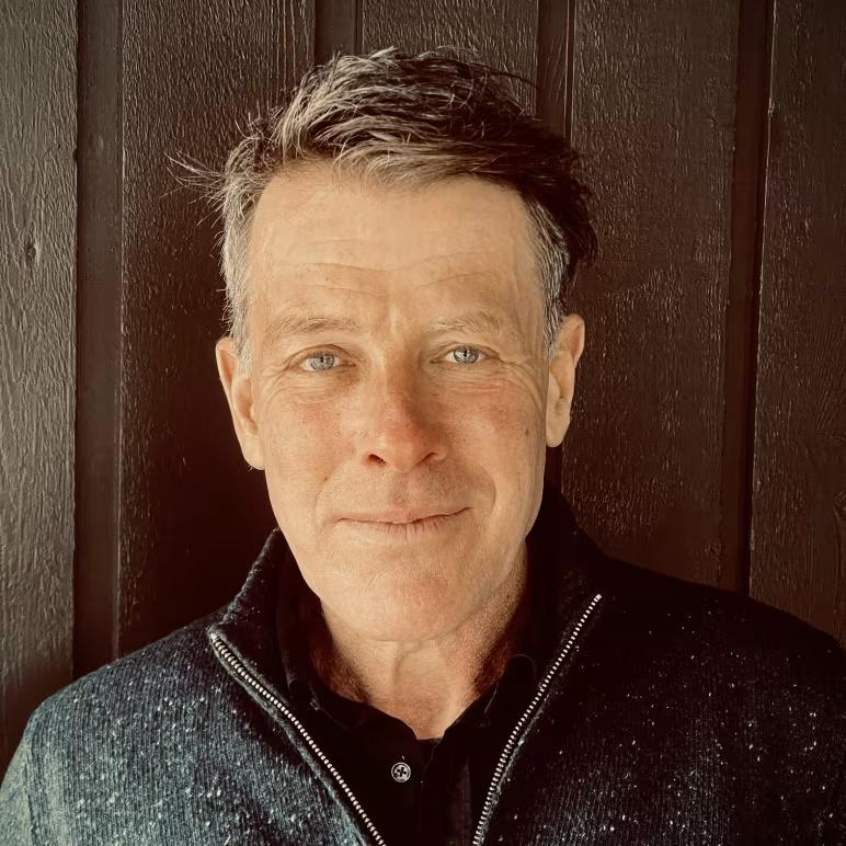 image of Jochen wearing a green jacket smiling at the camera