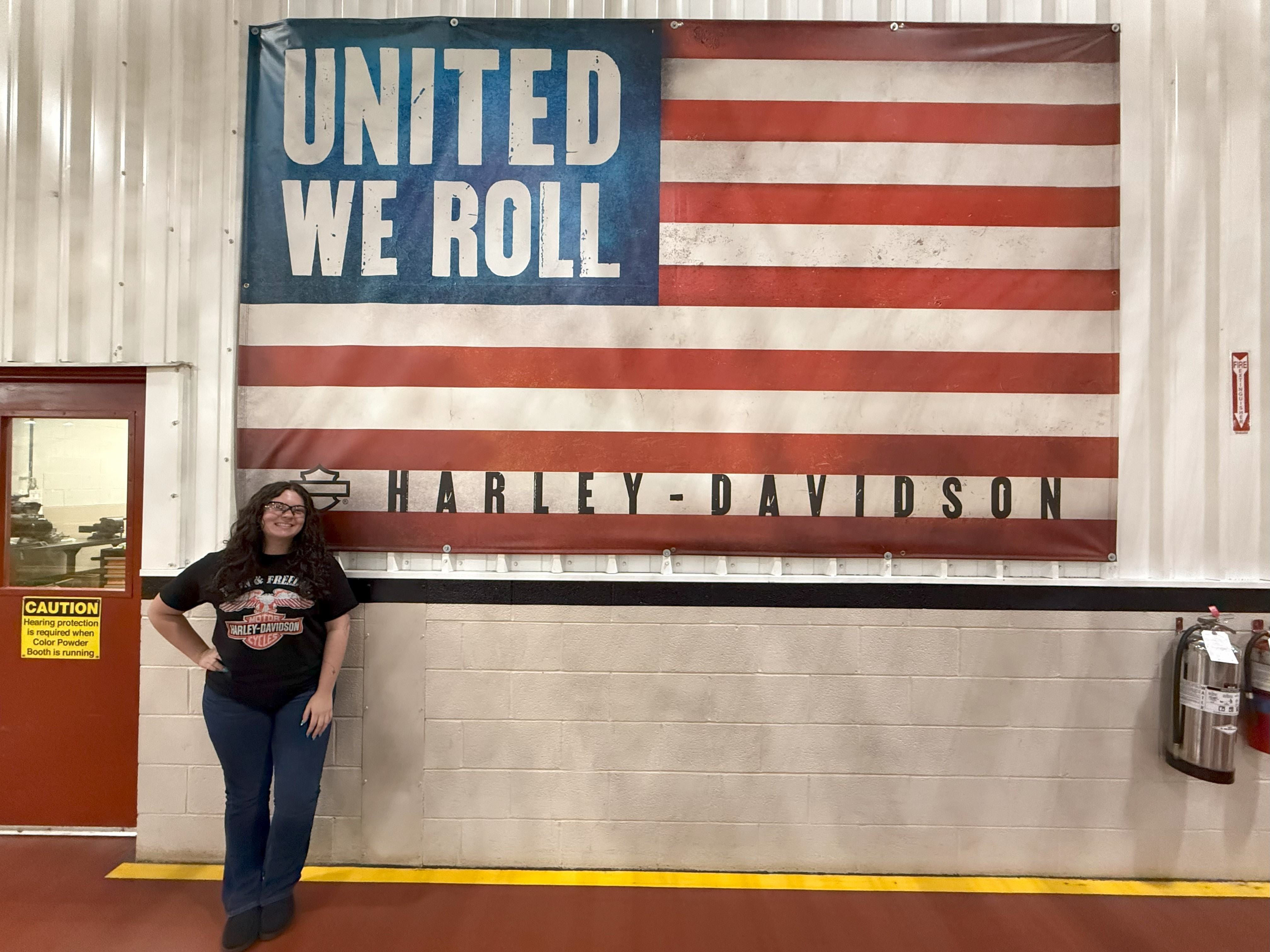 Brasten stands near an American flag that reads