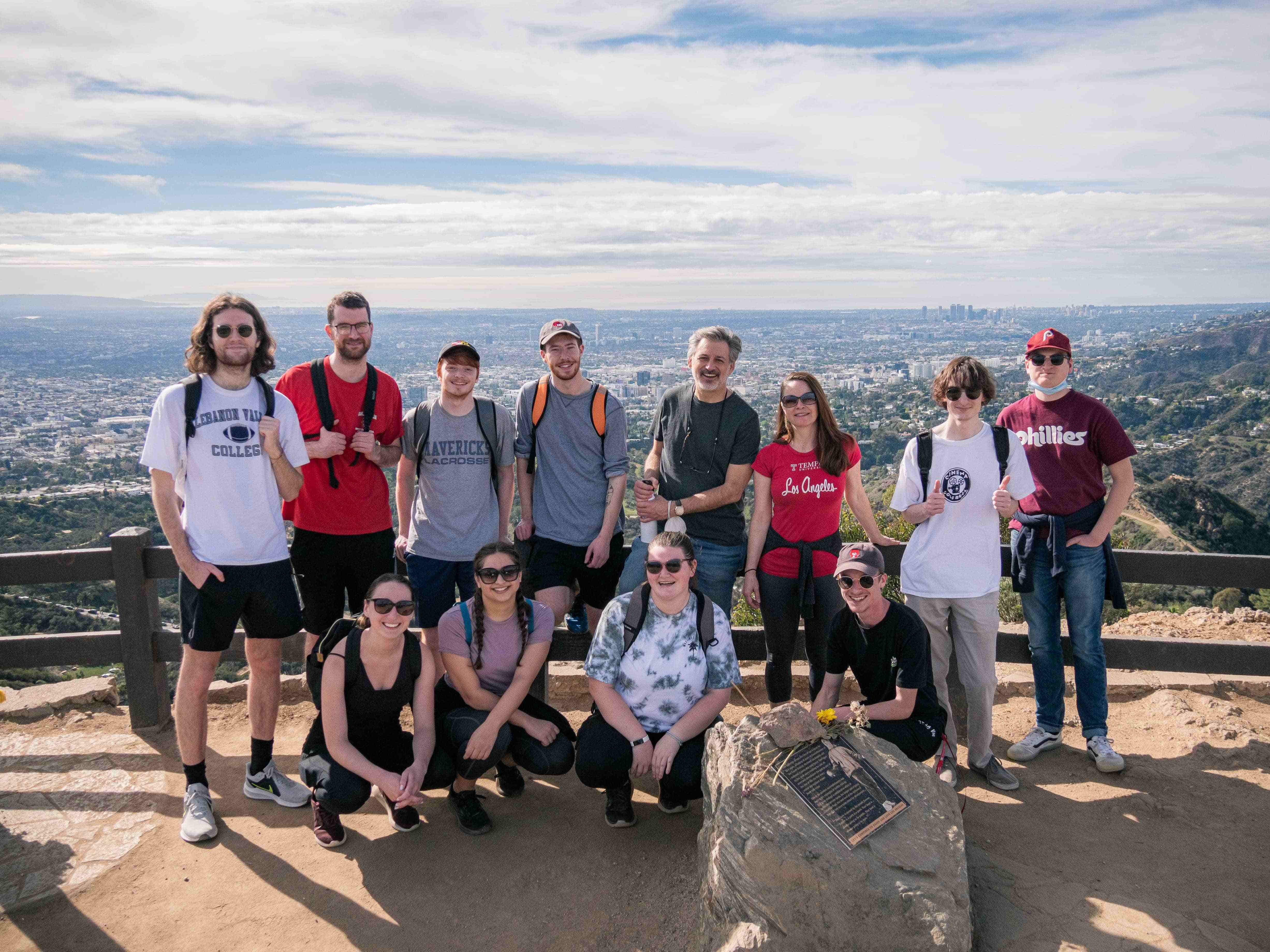 Image of students and faculty posing in front of a fence.