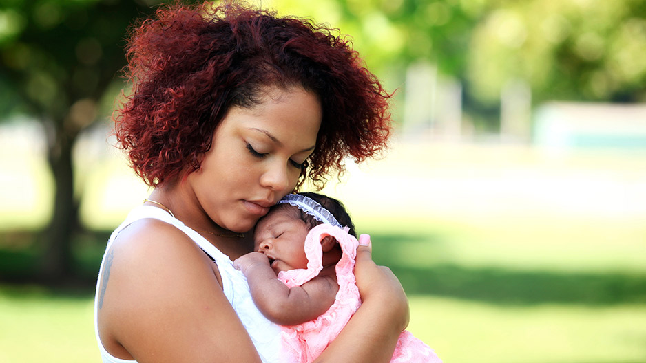 A mother holding a newborn baby girl.