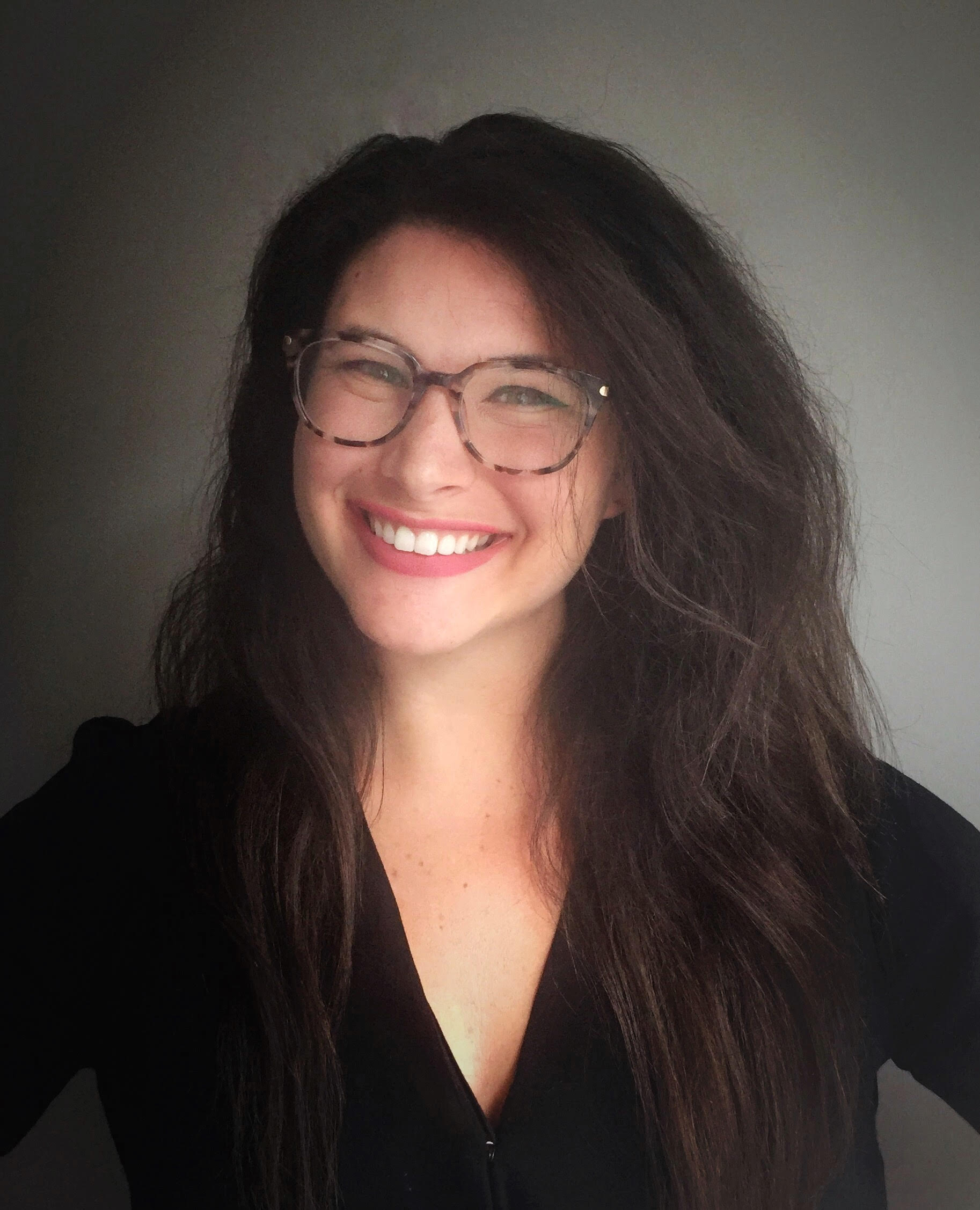 Image of Jeni Stolow posing in front of a gray background