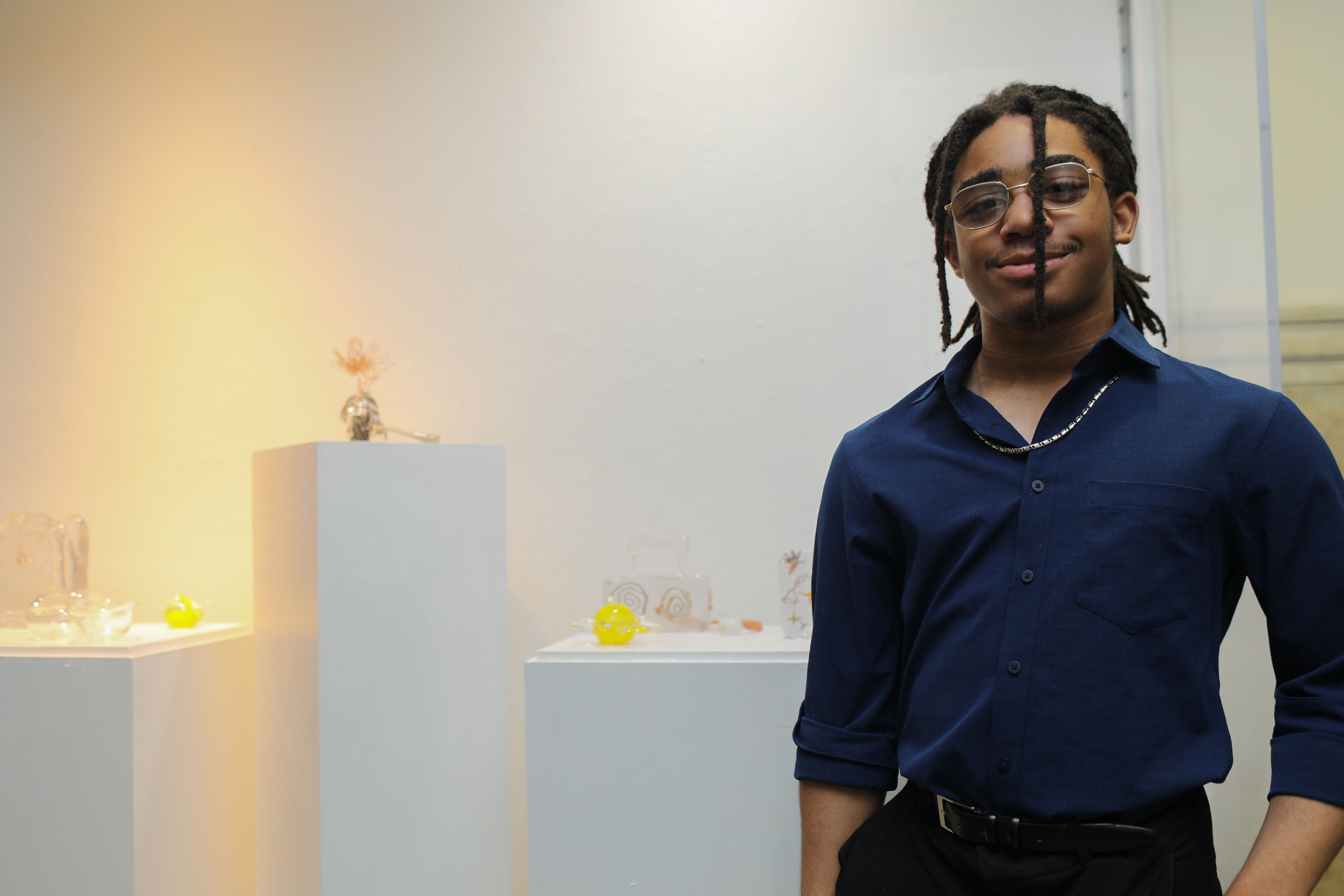 Creative Scholars student stands next to artwork