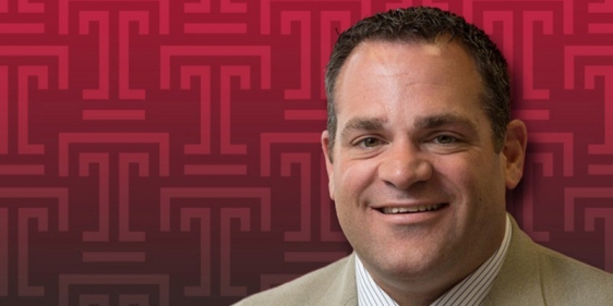 Pat Kraft posing in front of a Temple T background.