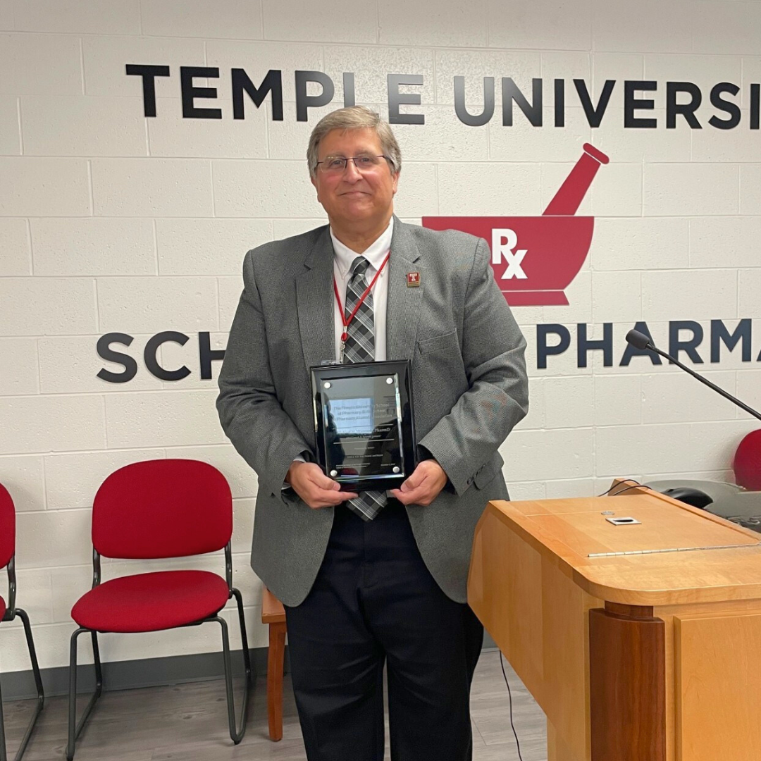 Dr. Mancano with an award plaque