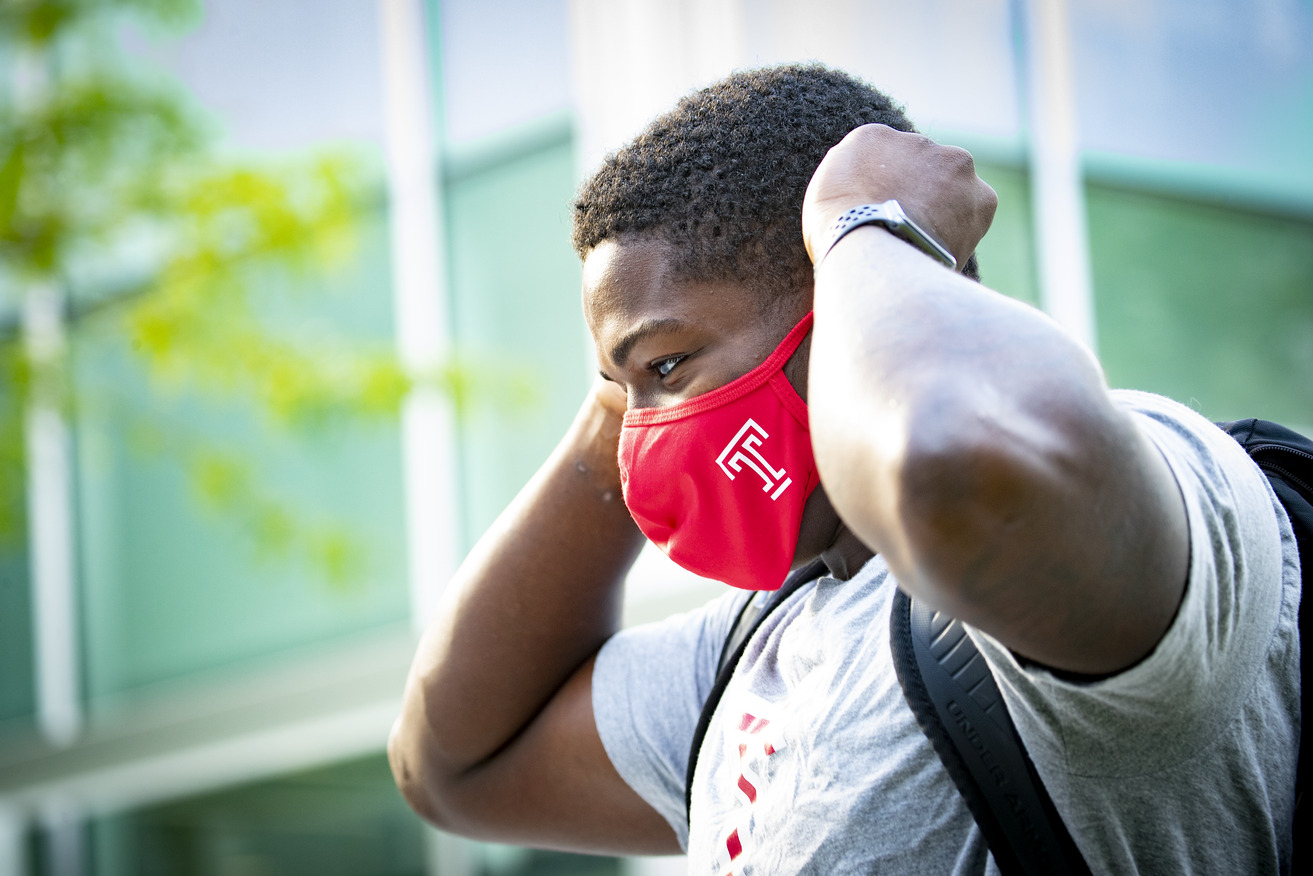 Student removing red Temple mask.