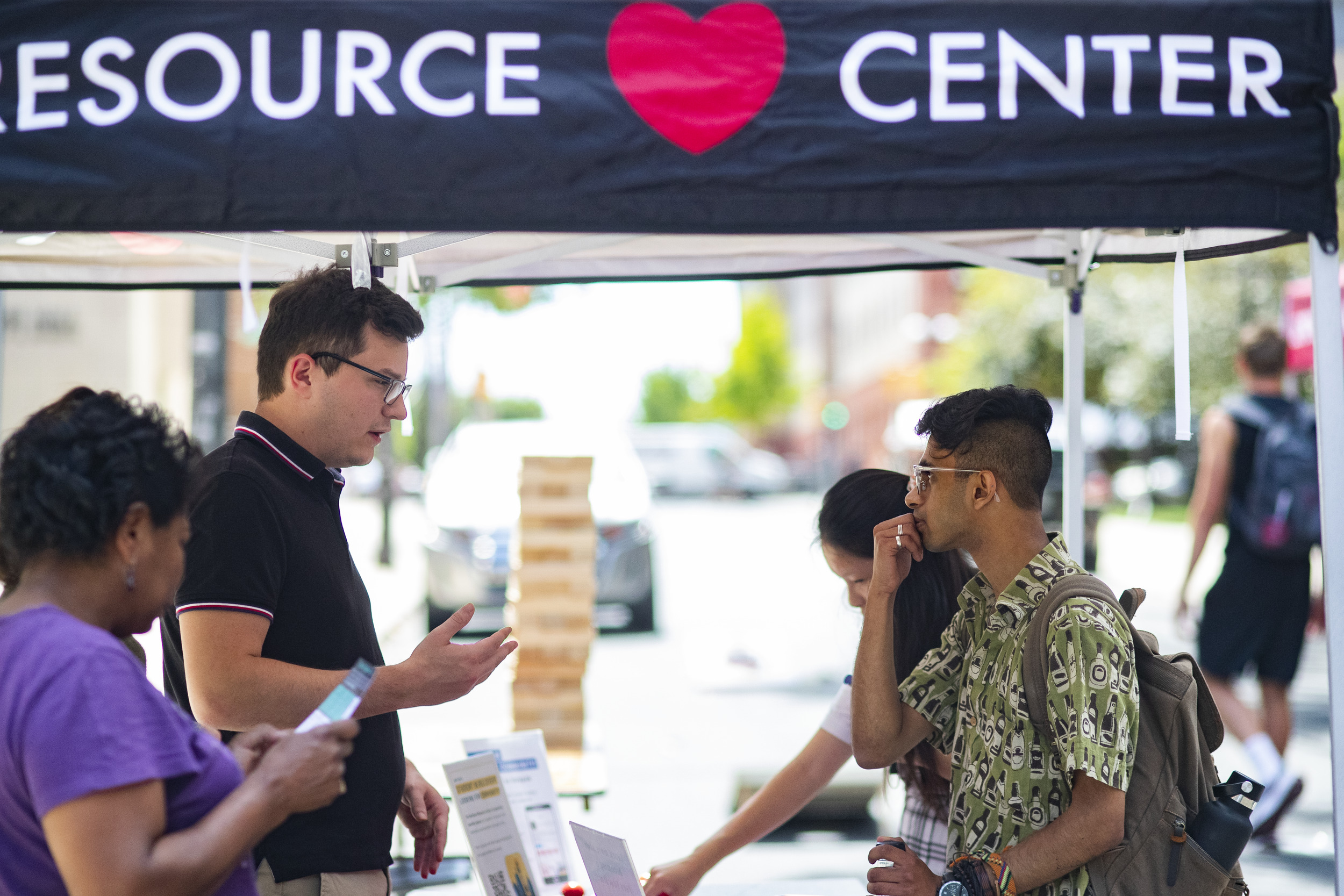 WRC staff member speaks with a student at an outdoor event.