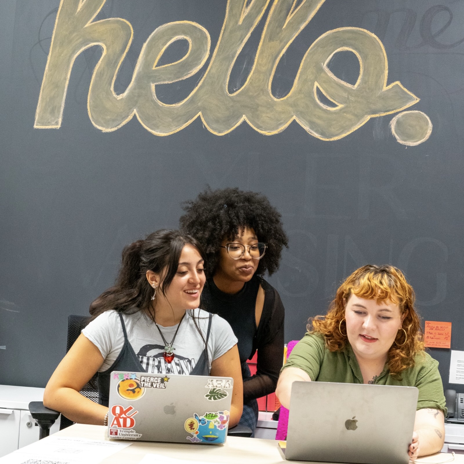 Students in Tyler Advising gather under a "hello" sign. 