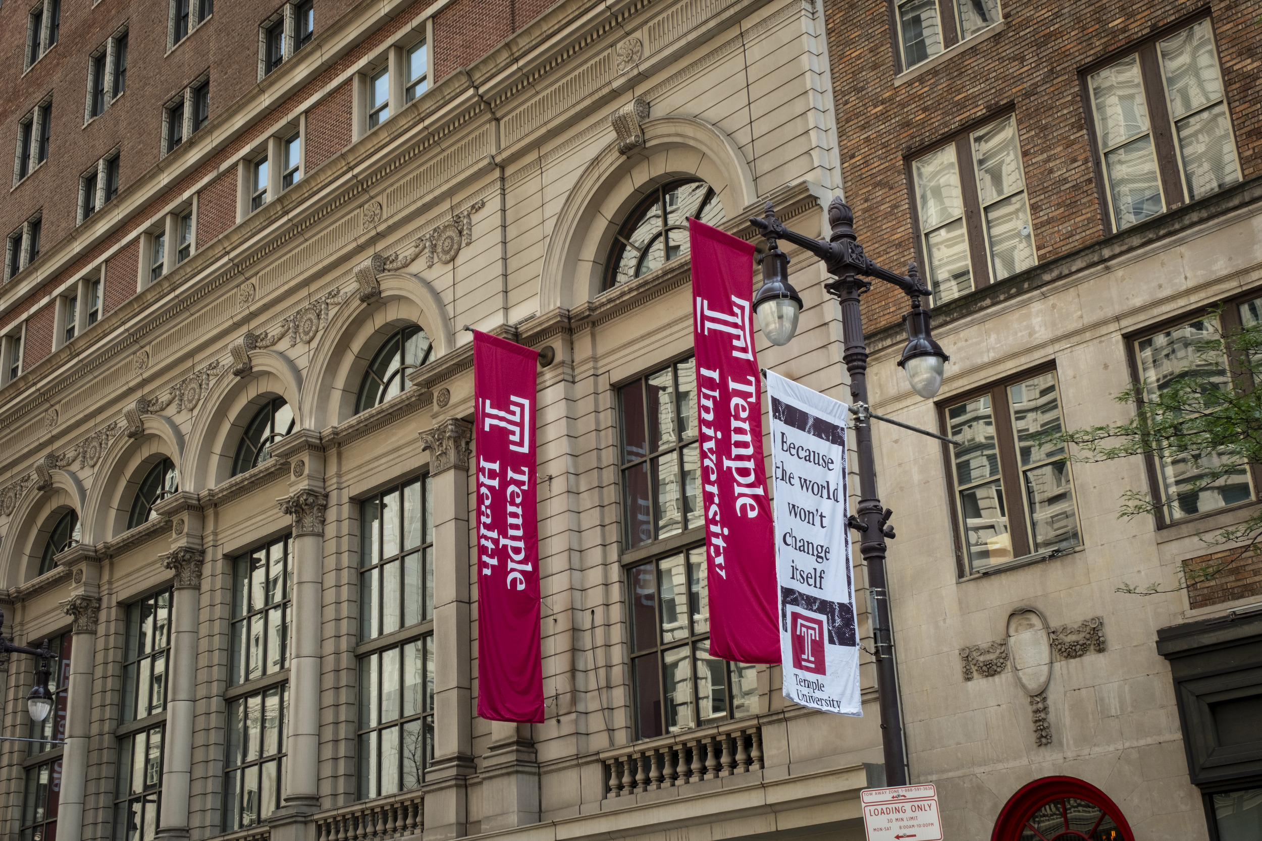 the facade of terra hallf with temple banners hanging from the side in between windows
