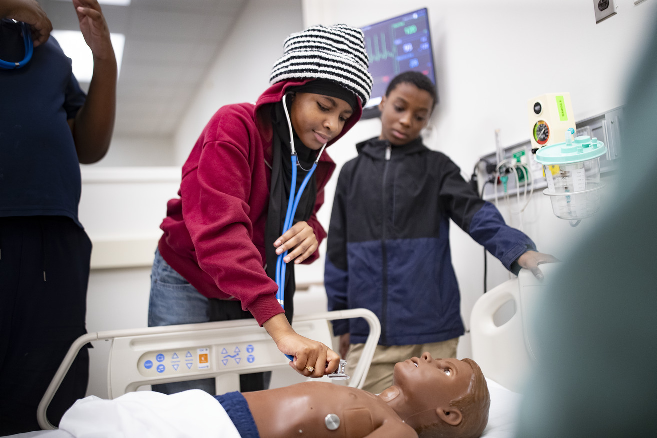 A Bethune Elementary School student practices listening to a heartbeat at the Lewis Katz School of Medicine simulation center.