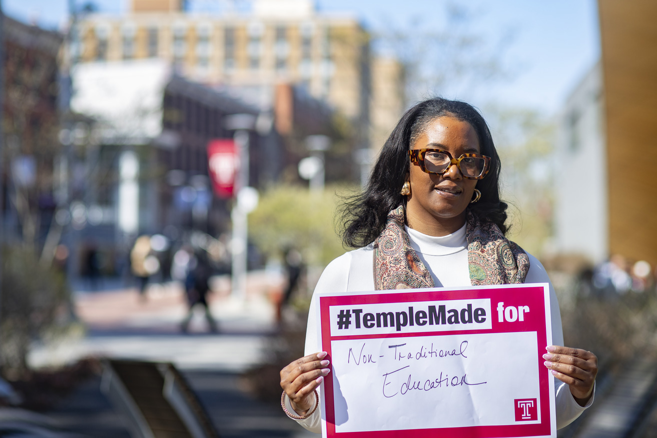 Jennifer Allen holding a Temple Made for sign outside on Main Campus