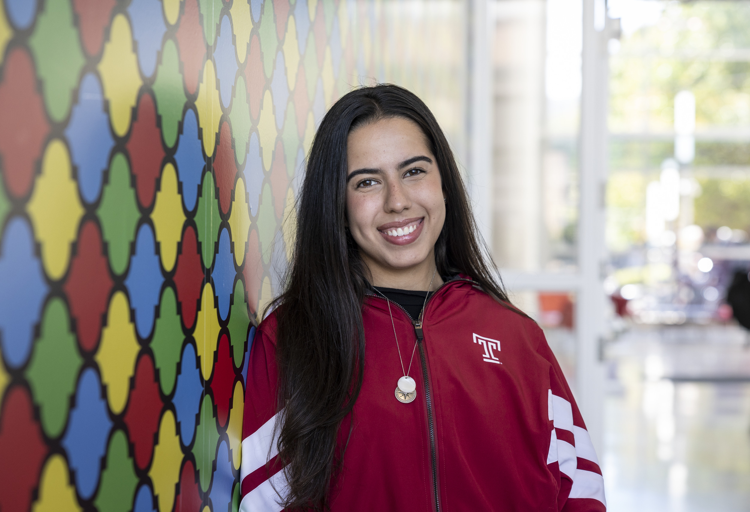 Raphaela leans against a colorful wall in the Art of Bread inside Tyler School of Art