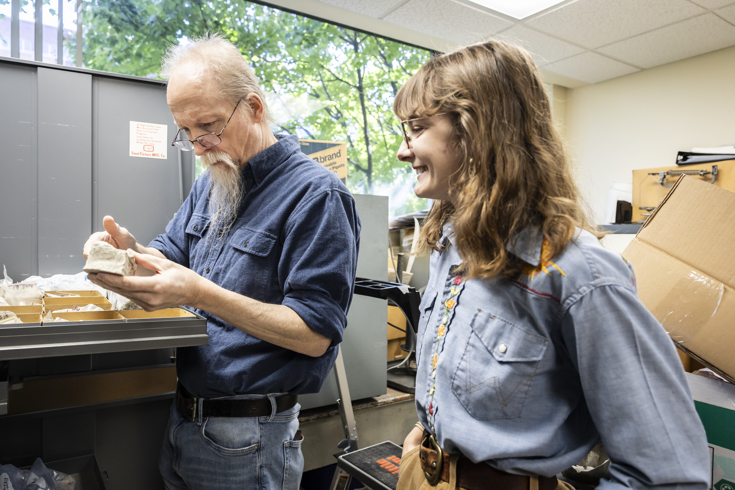 Image of of Terry and Shreero sorting through fossils in Terry's office.