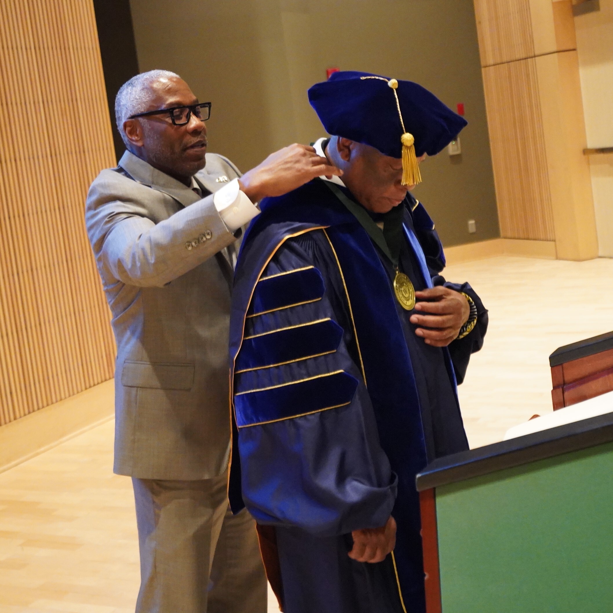 Dr. Asante receives medal from Timothy E. Sans