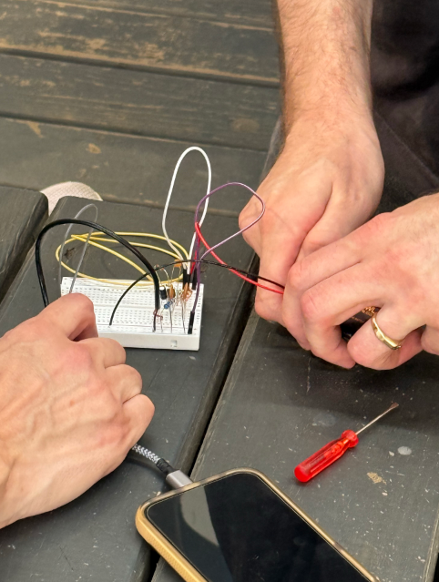 Hands building a transmitter.