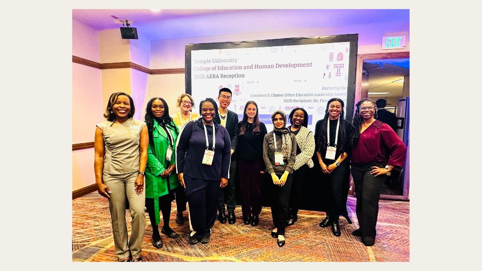 CEHD group of 10 gathers in front of a projection screen during the AERA 2025 reception