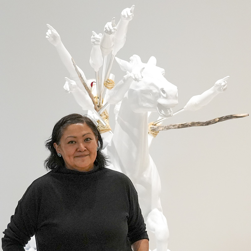 artist Anna Tsouhlarakis stands in front of her sculpture