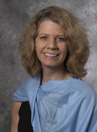 image of Beth wearing a blue wrap smiling at the camera