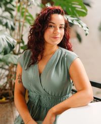 image of Betty sitting in a green dress looking at the camera