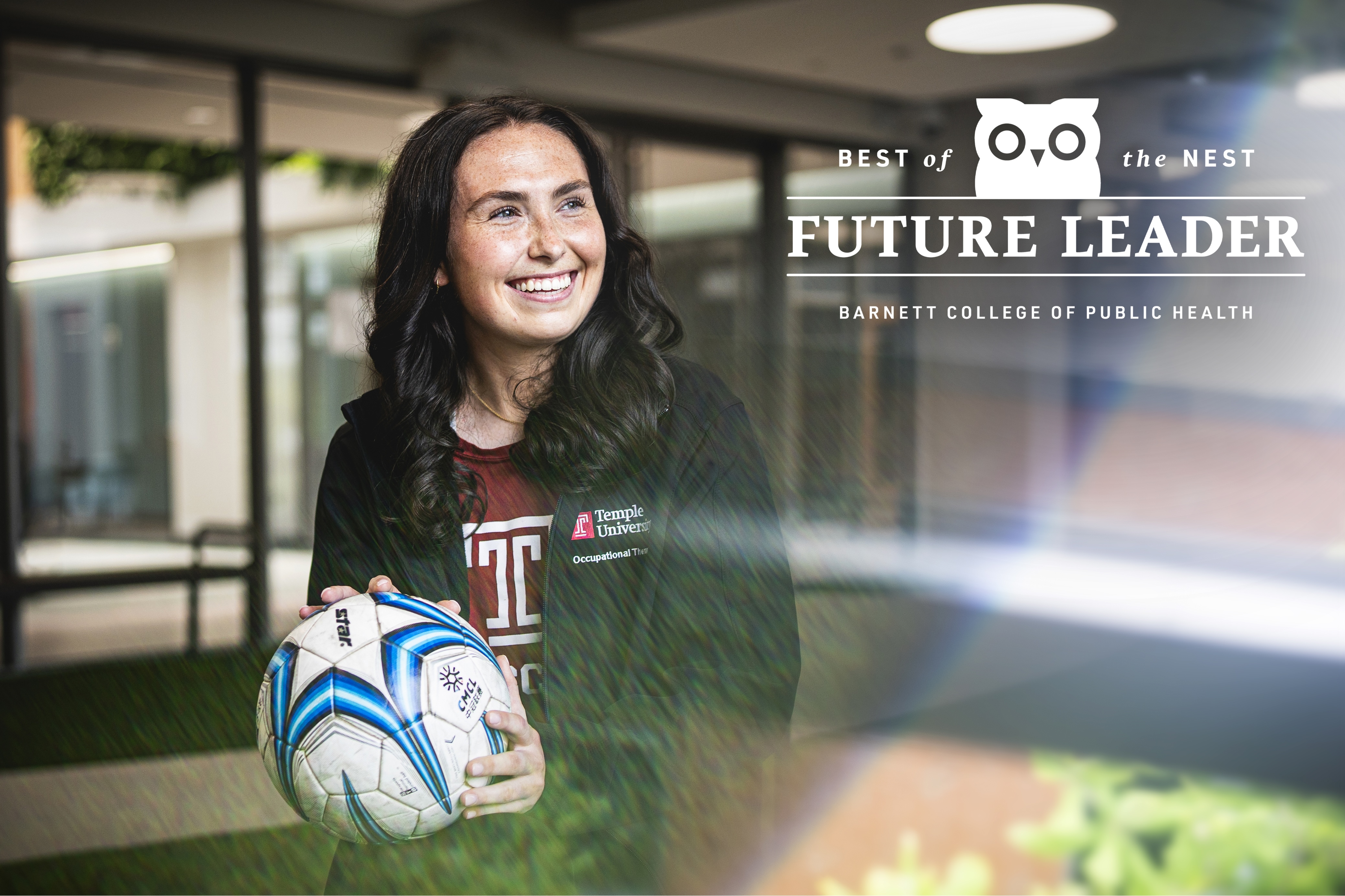 Student Brooke Kane holding a soccer ball and smiling.