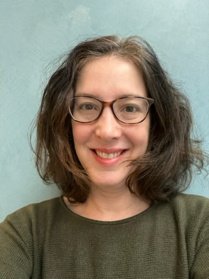 image of Elizabeth wearing glasses and a green top smiling at the camera