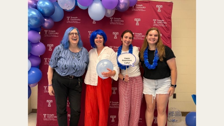Cathy Fiorello, left, stands with others at a photo wall during a party