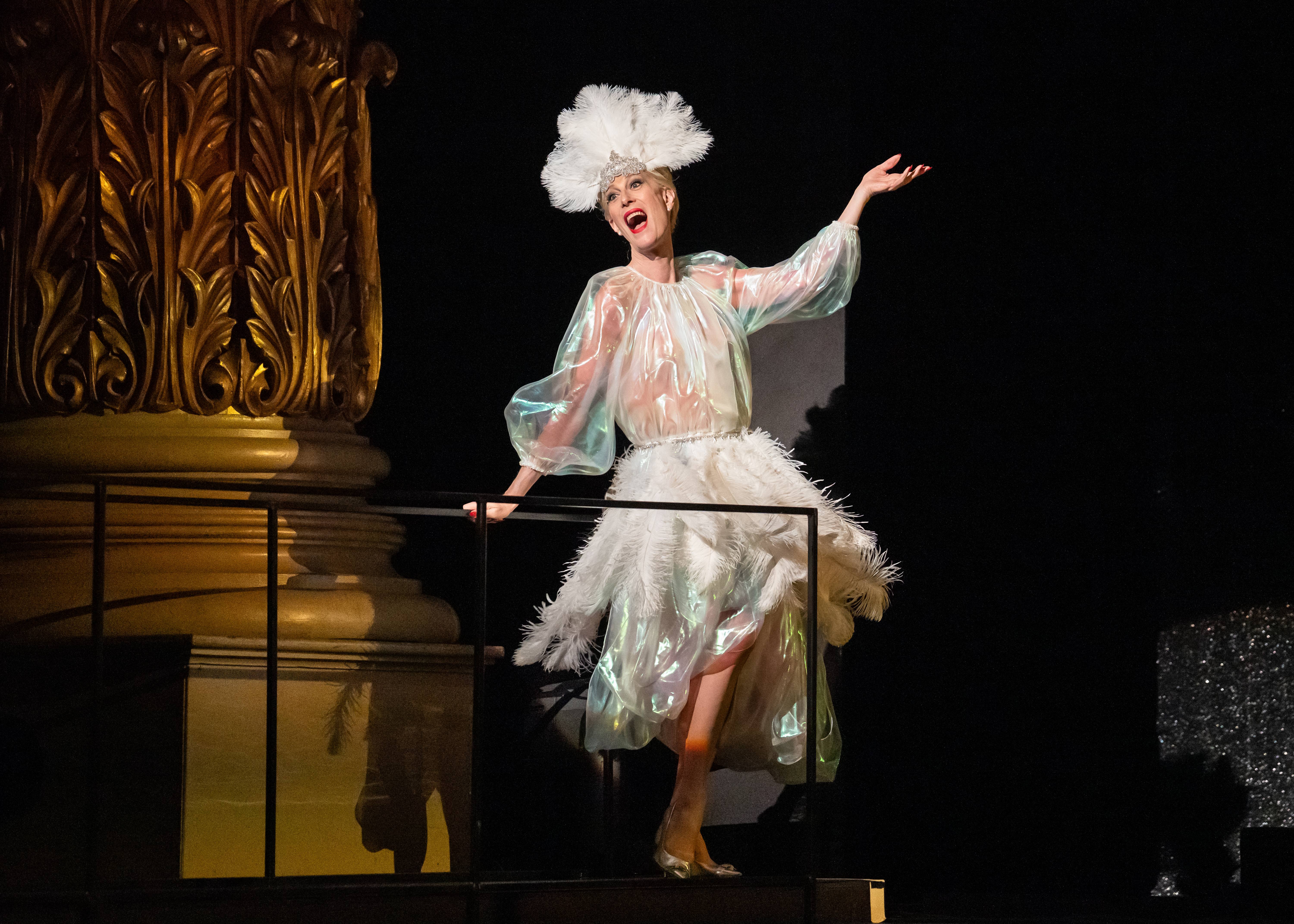 Photo of singer in white costume on stage performing