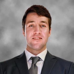 image of Connor wearing a suit and smiling at the camera