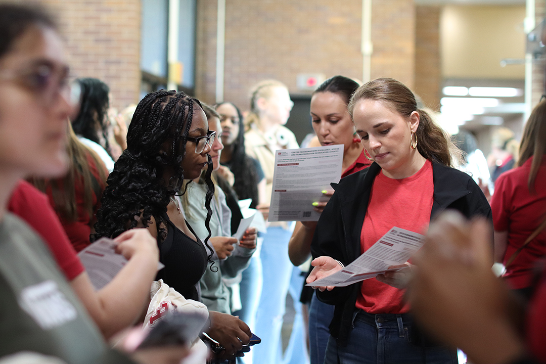 a crowd of students interacting with each other in a hallway