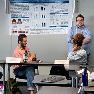 Student presenting a poster to other students.