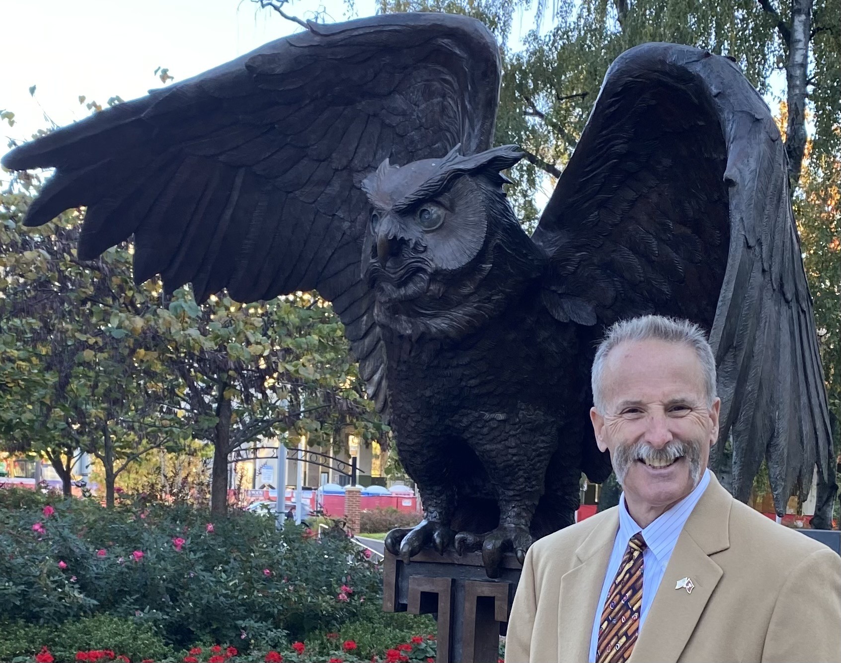 Dave Devereaux stands next to the Owl statue on Temple's main campus.