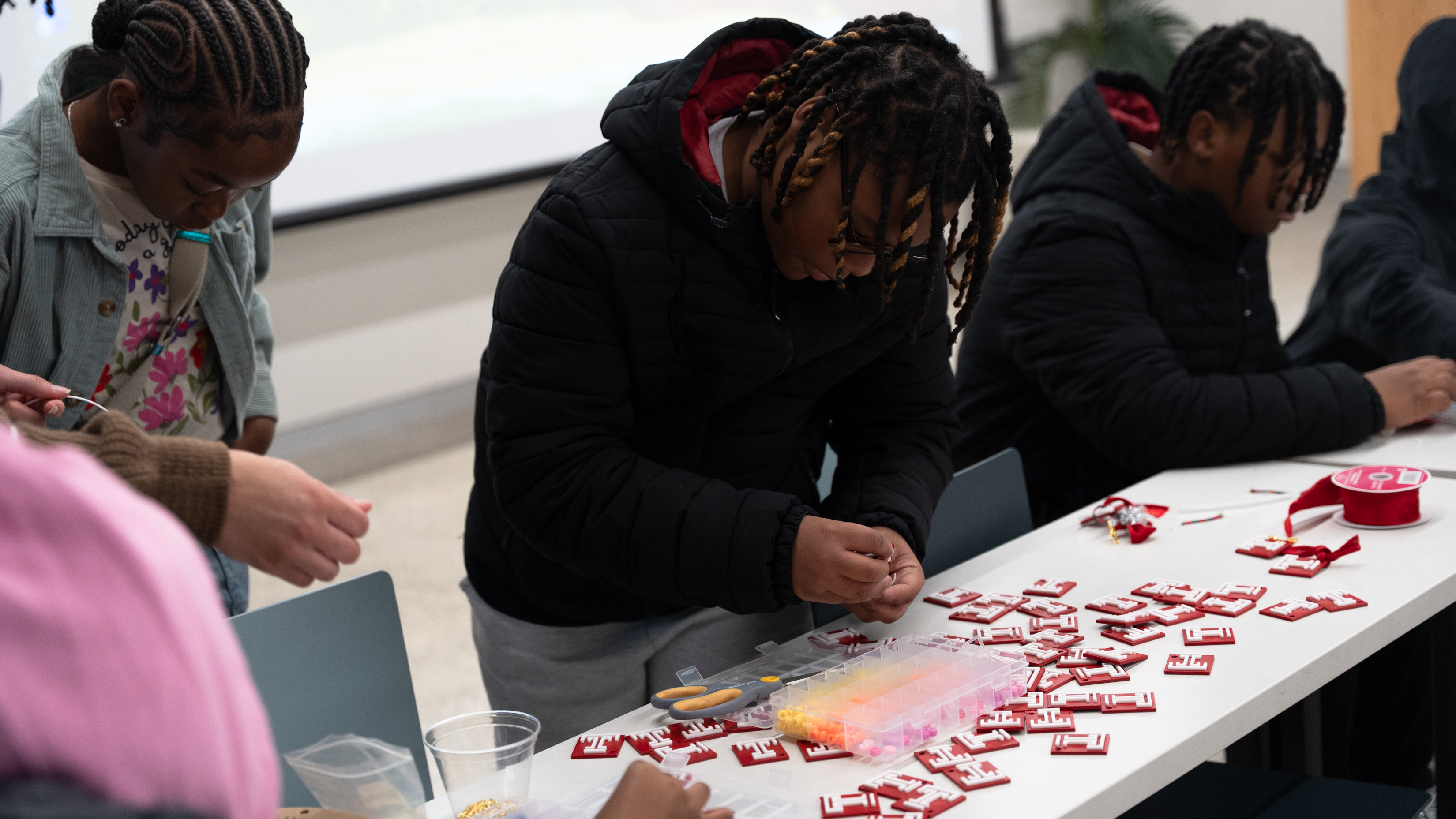 Students examining the 3D-printed Temple “T” icons to use for making keychains