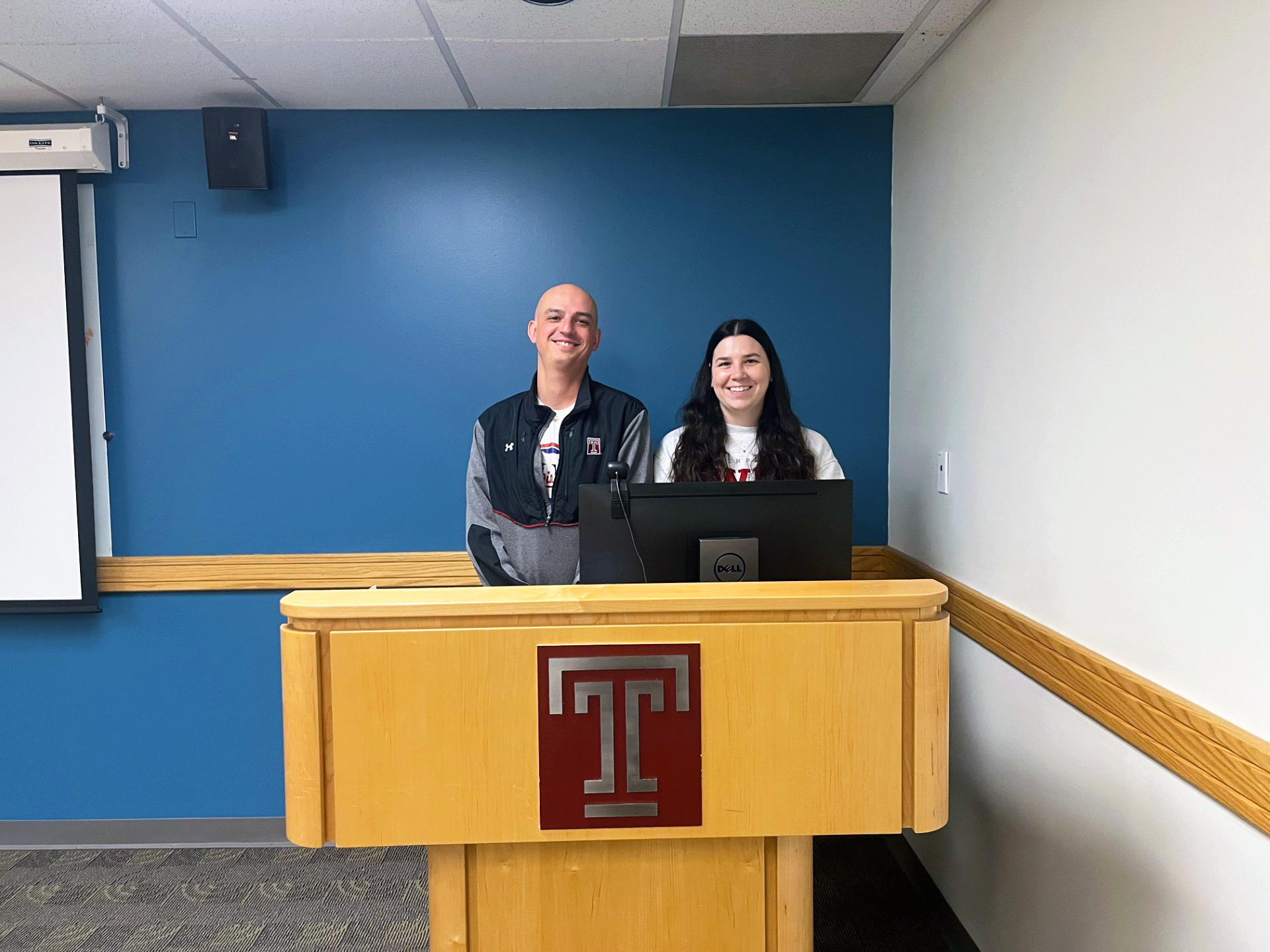 Two advisors stand at a podium