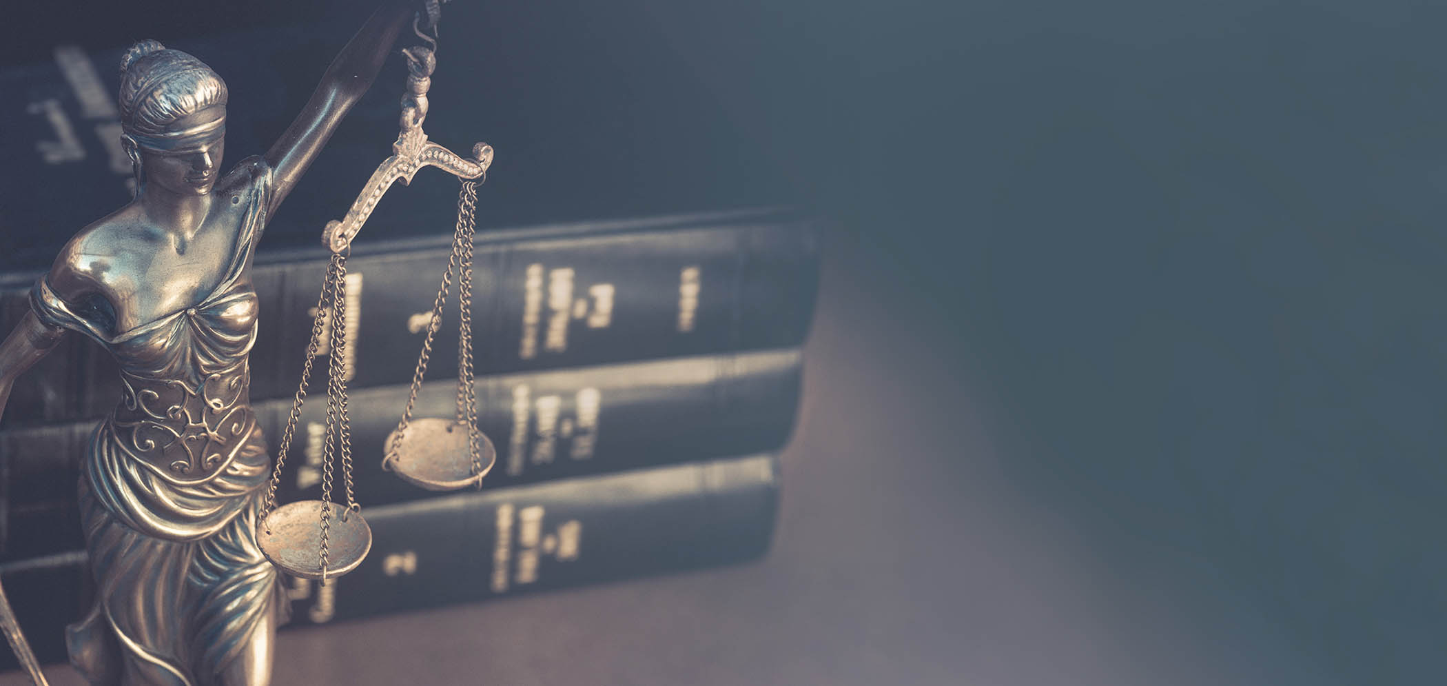 Image of blind justice statue in front of three law school books