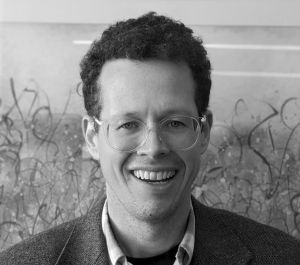 black and white image of speaker wearing glasses