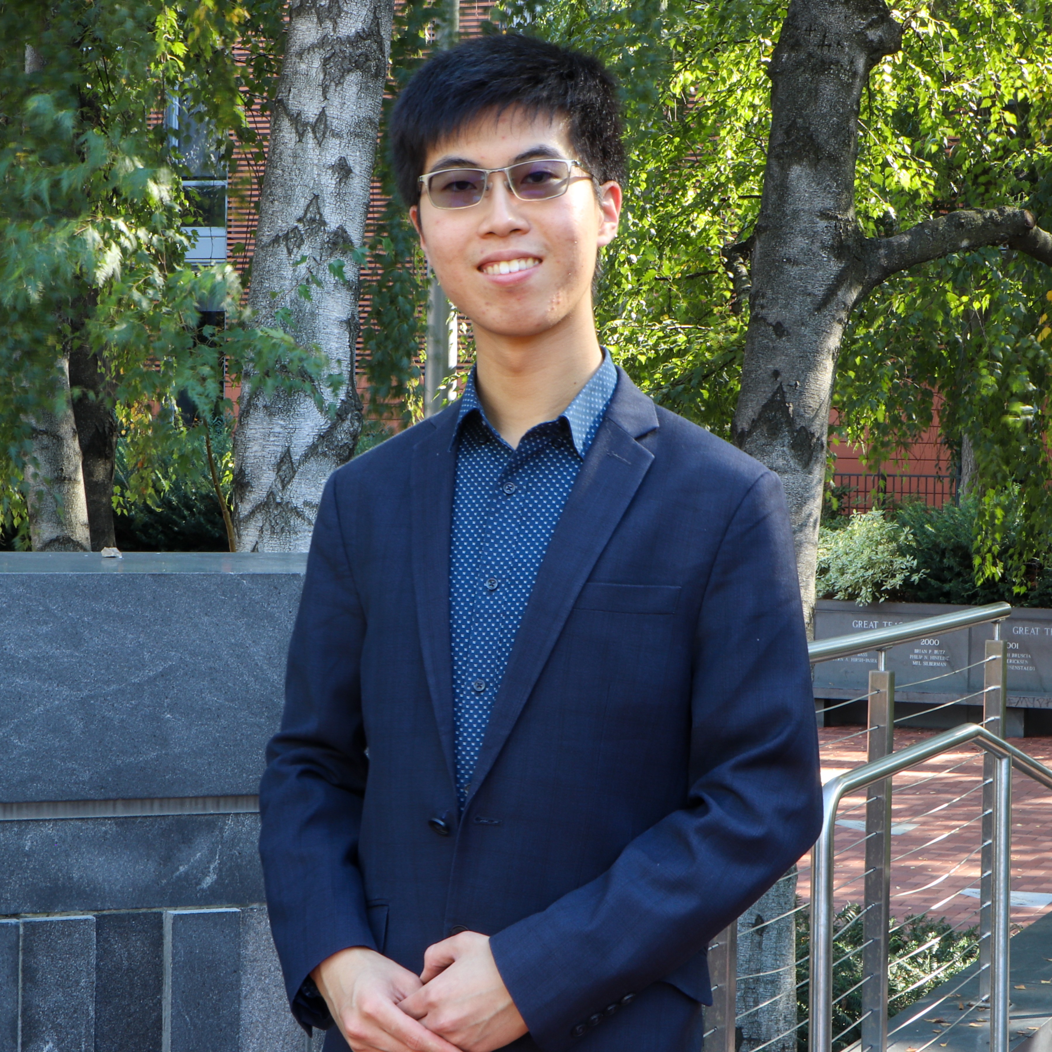 Photo of Hook Yang, a young man dressed in business attire, smilling at the camera.